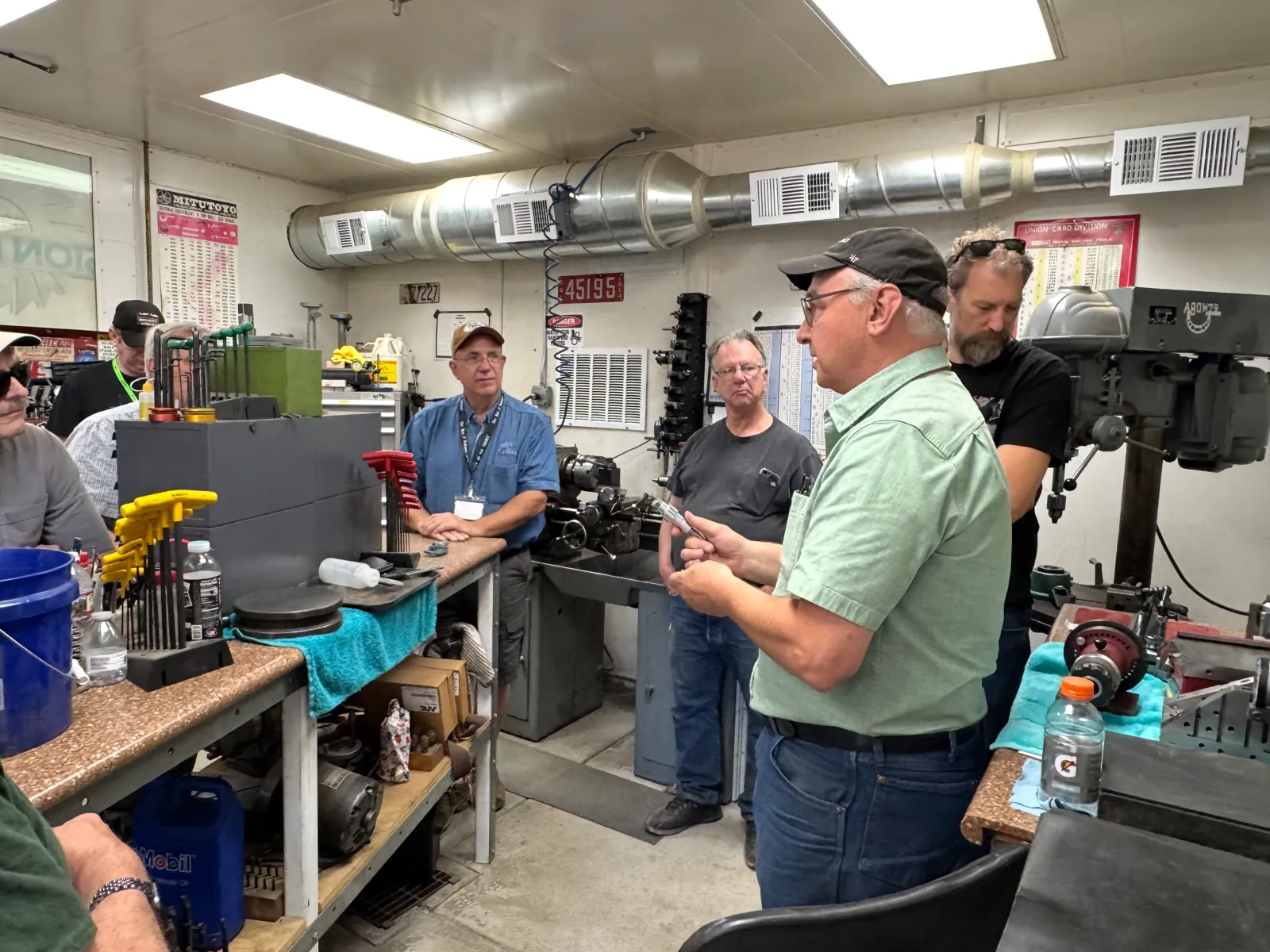 Gear School class gathered around an instructor in the shop